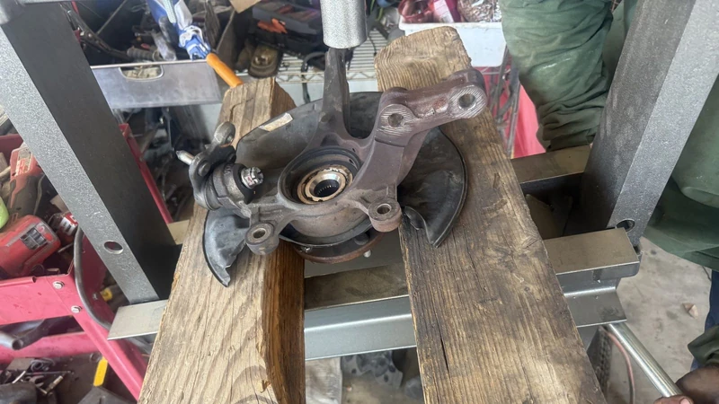 Steering knuckle and wheel hub out of a car on a work stand